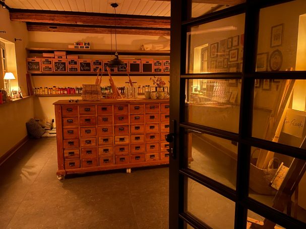 Ein gemütlicher Raum mit Holzregalen und zahlreichen Schubladen. Sanfte Beleuchtung.